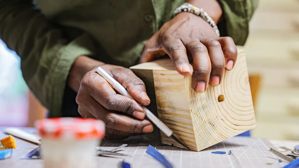 Personne découpant la paille avec un scalpel.